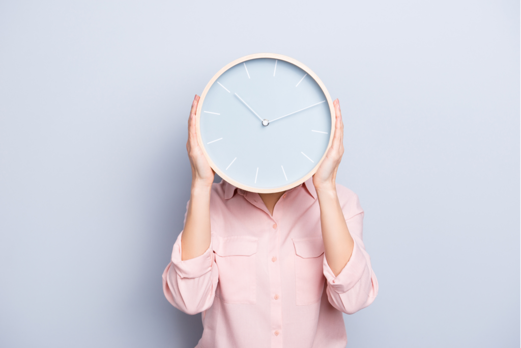 Here you an see a woman who is hiding her face behing a big clock to symbolize the importance of good Time and Project Management.