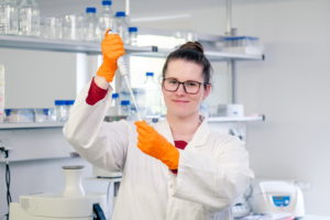 Womann holding a pipet in a laboratory.