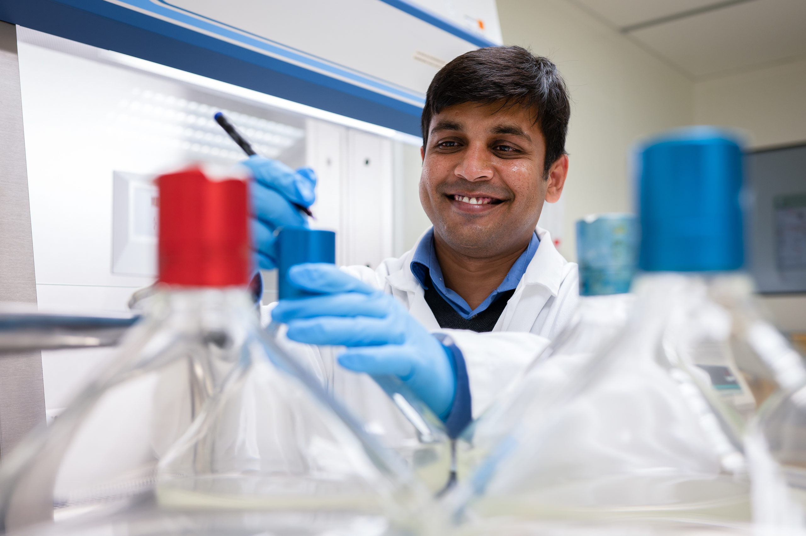 Man writing on a test tube in a laboratory.