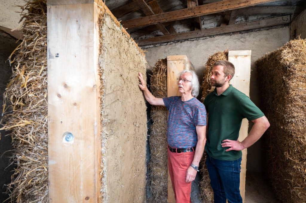 Werner Ehrich together with his colleague Tim Junghanns infront of a straw bale element.